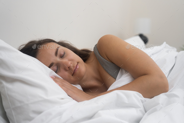 Orthopedic Comfort: young lady enjoys restful sleep with blanket on comfortable orthopedic mattress