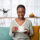Portrait of beautiful young black woman enjoying coffee at home - PhotoDune Item for Sale