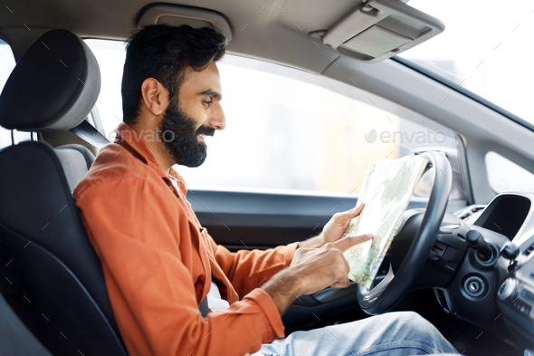 Smiling Indian Driver Man Holding Map Sitting In Modern Automobile