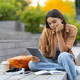 Upset young woman university student sitting at park, holding tablet - PhotoDune Item for Sale