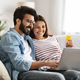 Cheerful indian couple using laptop and bank card at home - PhotoDune Item for Sale