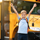 Back To School. Happy Boy Jumping Near Shool Bus And Raising Hands - PhotoDune Item for Sale