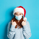 Christmas, quarantine and covid-19 concept. Cute teen redhead girl in santa hat and sweater - PhotoDune Item for Sale