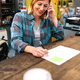 Portrait of smiling blonde young woman receiving order by phone for ecommerce shop - PhotoDune Item for Sale