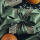 Gift box with a green ribbon tied in a bow, tangerines and small flowers.  - PhotoDune Item for Sale