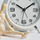 Wooden man sits near alarm clock. Concept of being late, long wait, transience of time, old age. - PhotoDune Item for Sale