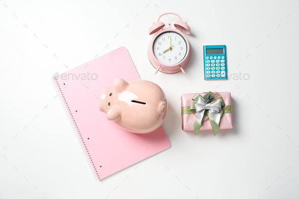Piggy bank, watch, calculator and gift box on white background, top view