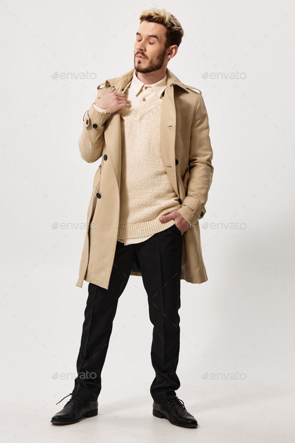 a man in a first coat and a sweater, do not touch his shoulder and look to the side hand in his
