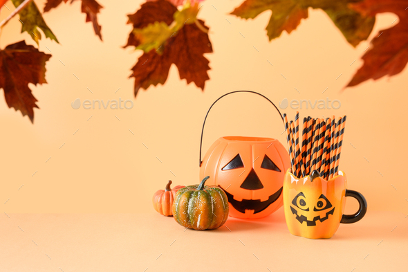 Halloween festive party decorations, candy bowl, pumpkins, funny mug with drinking straw.