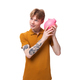 young man with red hair in an orange t-shirt holding a piggy bank - PhotoDune Item for Sale