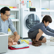 Single father and his son sitting the floor helping of sorting clothes, folding laundered items.  - PhotoDune Item for Sale