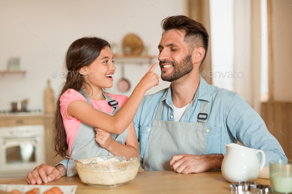 Father's Day Gifts From Daughters That Will Melt His Heart 7 Excited father and daughter bonding while cooking and baking together in kitchen, cooking pastry and Stock Photo by Prostock-studio