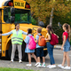 Black Female Teacher Assisting Children While They Entering School Bus - PhotoDune Item for Sale