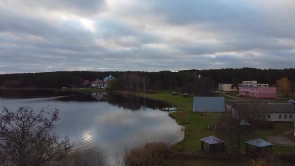 The drone rises above the lake on a cloudy autumn day