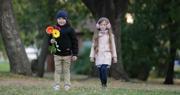 Little Girl Approached to the Little Boy in the Park alt