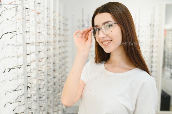 Young Woman with Eyeglasses in Optical Store - Beautiful girl wearing glasses in optician shop