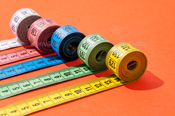 colorful measuring tapes top view on bright red background Stock Photo by  ilonadesperada