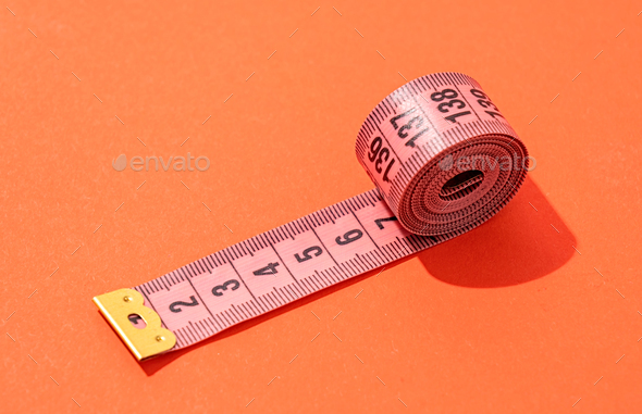 colorful measuring tapes top view on bright red background Stock
