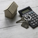House key and calculator over a wooden background. Real estate concept. - PhotoDune Item for Sale