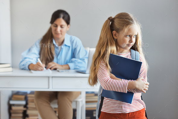 Little schoolgirl is worried about a grade on a test at school, a teacher checks the exam of school