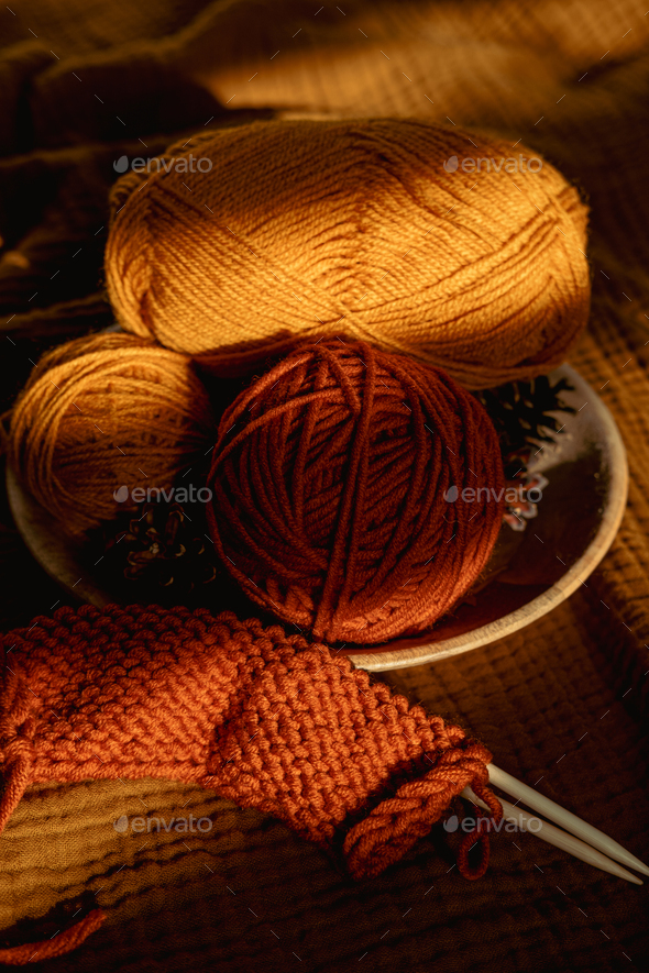 Earthy tones, warm colors yarn balls and knitting needles background. Cozy  Crafts and Hobbies Stock Photo by IrynaKhabliuk