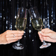 Close up of two people holding wine glasses against glittering party background - PhotoDune Item for Sale