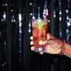 Close up of male hand holding cocktail against glittering party background - PhotoDune Item for Sale