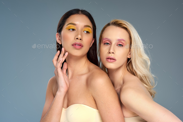 Female models with different skins standing together and smiling. Group of  happy young women on brown background Stock Photo - Alamy