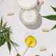 Cram jar, Pipette with CBD oil, capsules and Tea near green cannabis leaves. Alternative medicine - PhotoDune Item for Sale