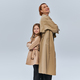 two generations, happy redhead woman and girl standing in trench coats with folded arms in studio - PhotoDune Item for Sale