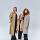 redhead family in autumn coats and standing together on grey background, happy female generations - PhotoDune Item for Sale