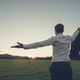 Businessman standing in green meadow looking towards the sunset - PhotoDune Item for Sale