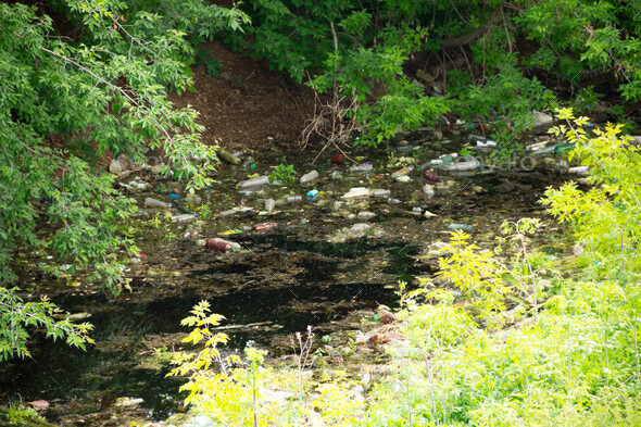 Illegal bulk waste discarded. Landfill in the river. polluted environment. problem concept