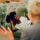 Woman is lying on the couch at a psychotherapist&#39;s office and having an individual session. - PhotoDune Item for Sale