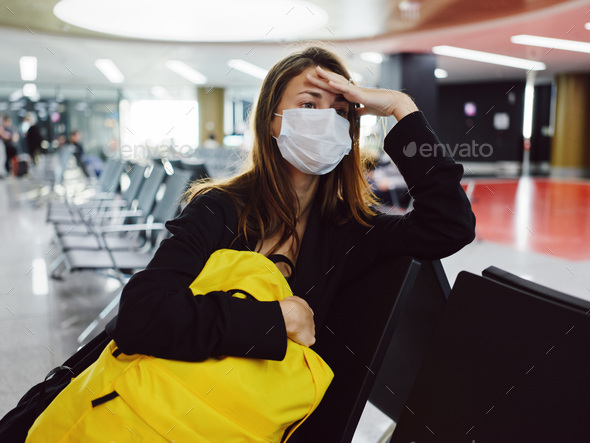 woman wearing medical mask eyes closed airport yellow backpack