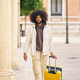 young afro man walking down the street with yellow suitcase - PhotoDune Item for Sale