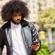 young man with afro hair looking at the phone - PhotoDune Item for Sale