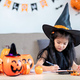 happy halloween. little girl draws a pumpkin and prepares to celebrate halloween at home - PhotoDune Item for Sale