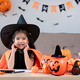 Cute little girl wearing a Halloween costume sits on the sofa with a happy. looking at the camera. - PhotoDune Item for Sale