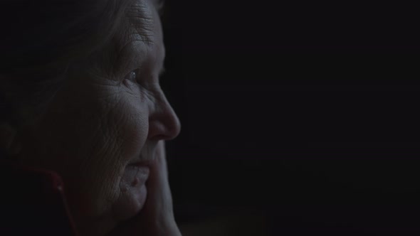 Slow Motion Handheld Shot of Old Woman Sitting Near Window Dark Lit