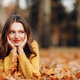 Young woman lies in autumn park ground with yellow foliage maple leaves around - PhotoDune Item for Sale