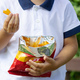 a boy eats chips in the park. Selective focus - PhotoDune Item for Sale
