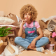 Photo of curly haired woman dressed casually has pensive displeased expression surrounded by - PhotoDune Item for Sale