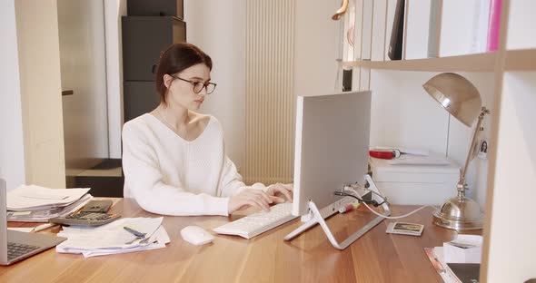 Young Business Woman in Glasses Working in Office Interior on Pc on Desk Typing alt