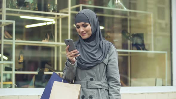 Happy Arabic Lady Using Online Shopping App for Searching Discounts, Fashion alt