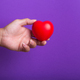 Hand with red heart on purple background. - PhotoDune Item for Sale