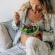 A pregnant woman eats green fresh vegetable salad taking care of her health. - PhotoDune Item for Sale