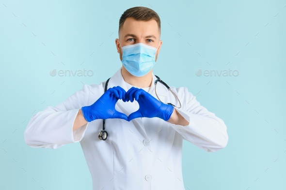 Doctor's hands in medical gloves in shape of heart on blue