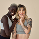 Two happy diverse fit women wearing sport tops standing on background,  portrait. Stock Photo by insta_photos