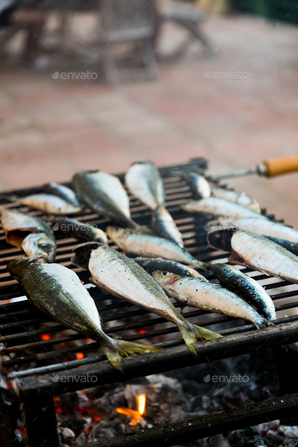 Fresh fish sadrines on a grill, summertime backyard dinner concept